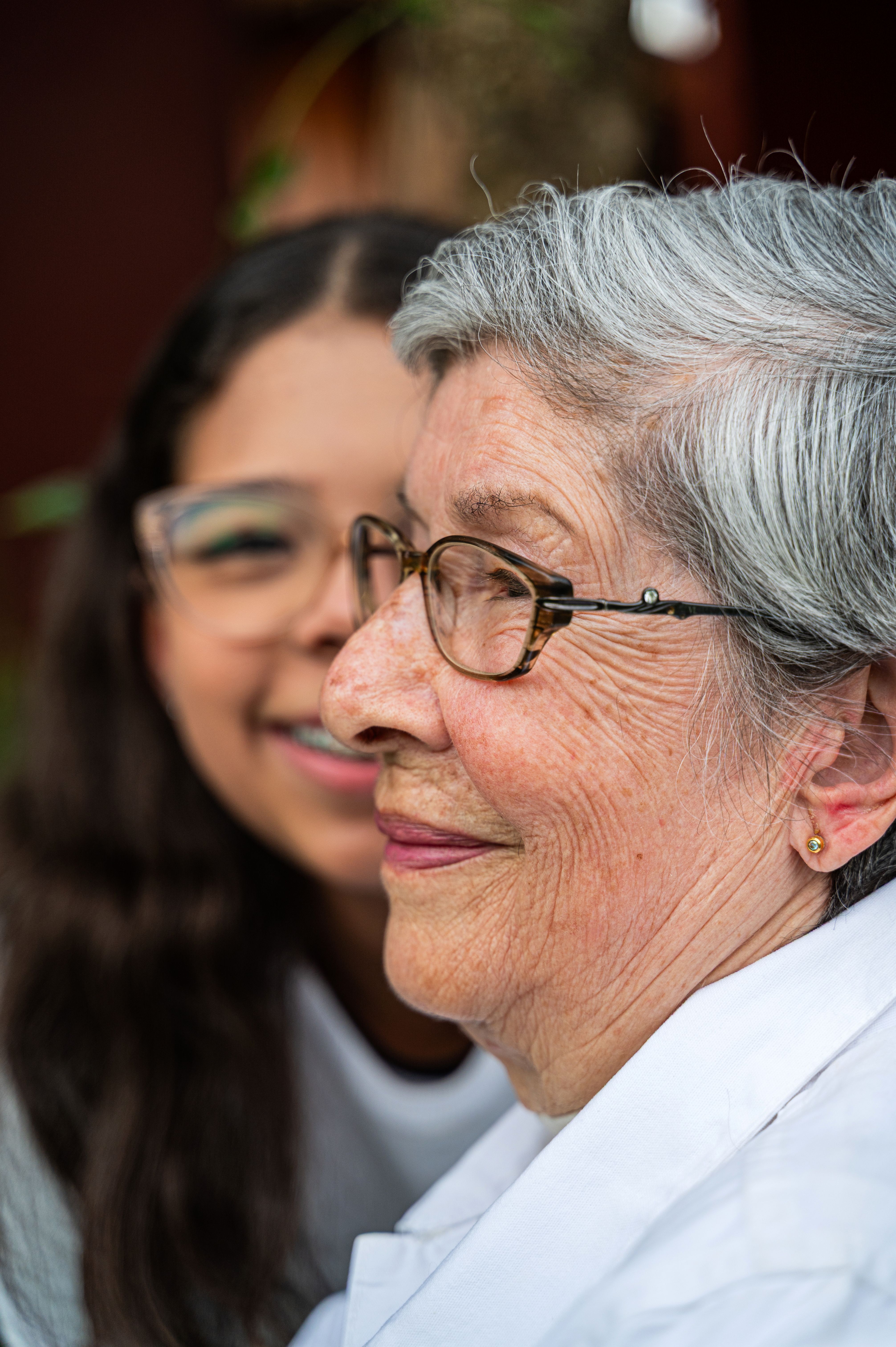 Avó e neta sorrindo juntas, em um momento de afeto entre gerações